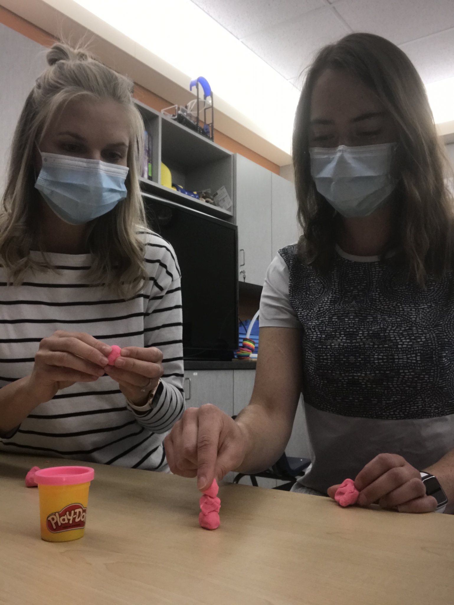 Two women playing with pink playdough