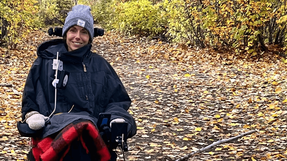 Chantelle smiling outdoors on a fall day in wheelchair