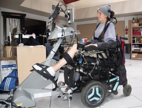 Chantelle on the functional electrical stimulation (FES) bike at the Glenrose