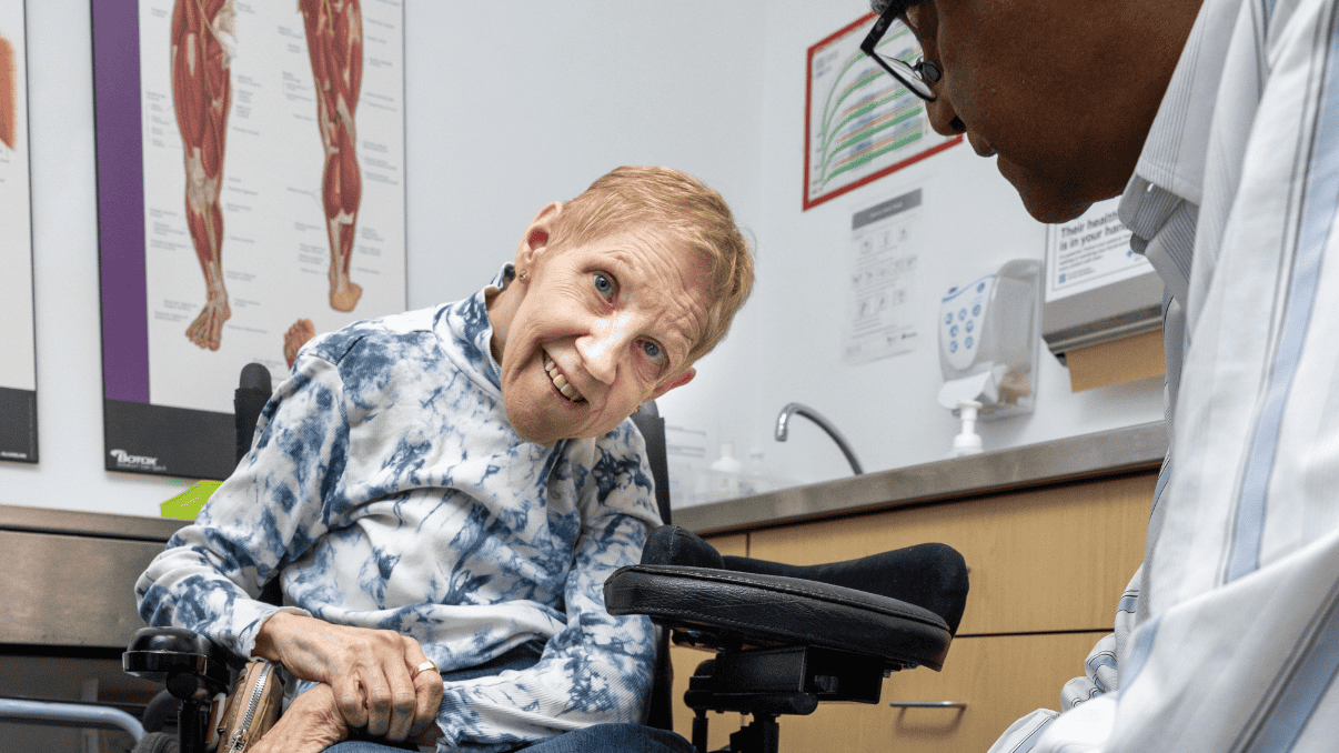 Elderly woman undergoing stroke rehabilitation with a healthcare professional.