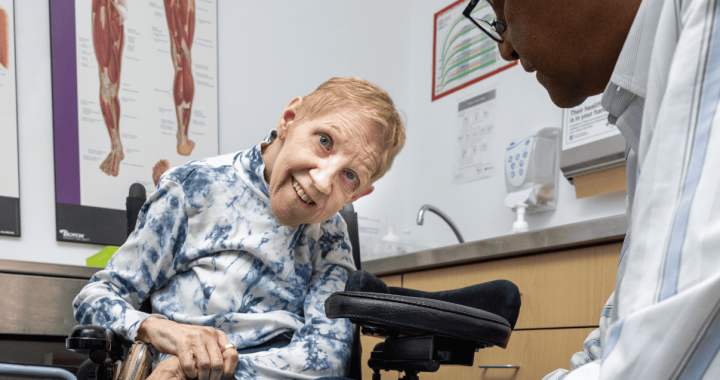 Elderly woman undergoing stroke rehabilitation with a healthcare professional.